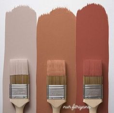 three paintbrushes with different shades of orange, pink, and brown on them