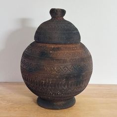 a brown vase sitting on top of a wooden table