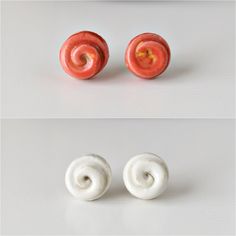 two different views of the same pair of red and white ear studs, one with an orange swirl on it