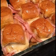 several sandwiches in a baking dish with cheese and meat on the top, ready to be eaten