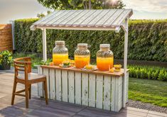 an outdoor bar with orange juice and lemonade in mason jars on the outside patio