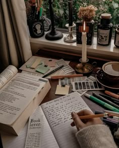 an open book sitting on top of a desk next to a window