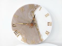 a white clock with roman numerals on the face is shown against a white background