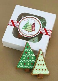 two decorated christmas trees sitting in front of a box