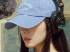 a woman wearing headphones and a blue hat with the word detroit written on it