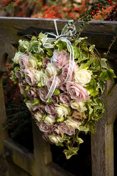 a heart shaped bouquet hanging on a wooden fence