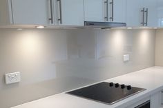 a stove top oven sitting inside of a kitchen next to white cabinets and cupboards