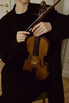 a woman sitting in a chair holding a violin