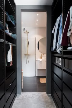 a walk in closet with black cabinets and white walls