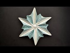 an origami snowflake made out of dollar bills on a black background