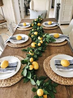 the table is set with plates and place settings for lemons on top of leaves