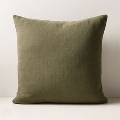 a green pillow sitting on top of a white table