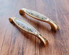 two wooden handles with flowers on them sitting on a wood table next to each other