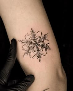 a snowflake tattoo on the left arm