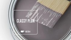 a paint can with a brush in it and the words classy plum on it