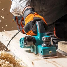 a person using a sander to cut wood planks with a power tool on it