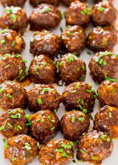 meatballs with chives and seasoning in a white dish on a wooden table