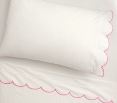 two white pillows with pink scallops on them