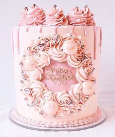 a pink frosted birthday cake decorated with roses