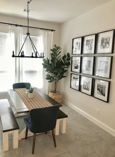 a dining room table with chairs and pictures on the wall