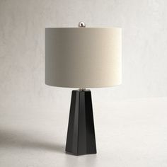 a black table lamp with a white shade on it