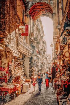 people are walking through an alley way in the city