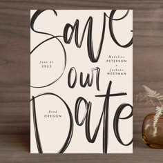 a card with the words save our date on it next to a vase filled with flowers