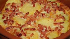 a casserole dish with bacon and cheese in a brown bowl on a table