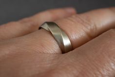 a person's hand with a wedding ring on it