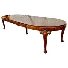 an oval shaped wooden table with glass top