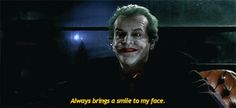 the joker is sitting down with his face painted like a clown and saying, always bring a smile to my face