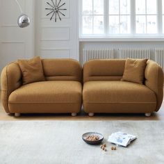 a brown couch sitting on top of a white rug