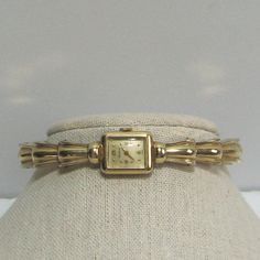 Vintage from the 1950s and pre-owned is this ladies Benrus Cuff Wristwatch. The watch has wonderful Art Deco styling and is completely 10 KT gold filled, it is marked/etched on both the watch case and cuff bracelet. The sturdy cuff opens/expands to fit a small wrist, 6 - 7", is very secure when on and is in very good condition. The watch bezel, face, crystal and crown are all in very good condition. On the watch face is written, "Benrus" at the top and "Swiss" at the bottom. On the case back are numbers along with 10KT GF. The watch is non working. But the overall condition is so good, without any dents or scratches, that it is well worth fixing. This 1950s ladies Swiss Benrus Cuff Wristwatch with its Art Deco styling will be a wonderful part of your collection and be eye-catching when wor Luxury Art Deco Jewelry And Watches For Women, Luxury Art Deco White Gold Watch, Luxury Antique Watch Accessories For Anniversary, Vintage Watch Women Cartier Tank, Luxury Vintage Watches With Tachymeter, Luxury Vintage Watch Accessories With Stainless Steel Clasp, Vintage Gold Cocktail Watch, Adjustable Vintage Watch Accessories, Vintage Ladies Watch