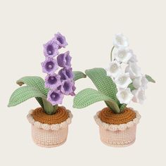 two crocheted potted plants with purple and white flowers