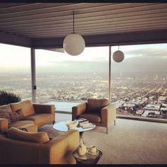 a living room with two couches and a table in front of a large window