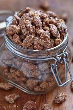 a glass jar filled with granola sitting on top of a wooden table