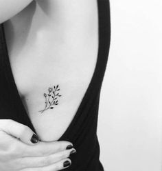 black and white photo of a woman's chest with a flower tattoo on it