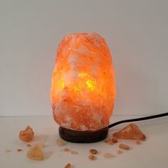 an orange himalayan salt lamp sitting on top of a table