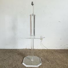 a glass and metal stand on carpeted floor