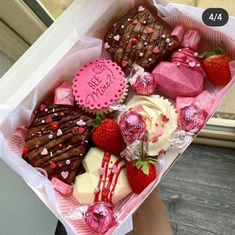 a box filled with assorted valentine's treats sitting on top of a window sill