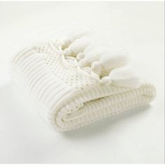 a white blanket with tassels on it