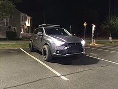 a silver suv parked in a parking lot at night