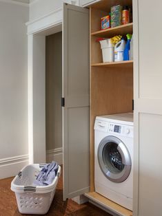 a washer and dryer in a small room next to a cabinet with doors