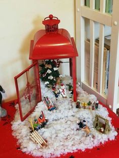 there is a small red lantern on top of the pile of fake snow and toys