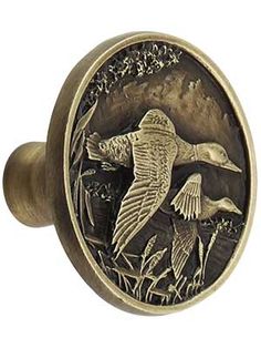 an antique style door knob with a bird on it