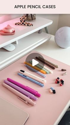 an apple pencil case sitting on top of a desk next to various pens and markers