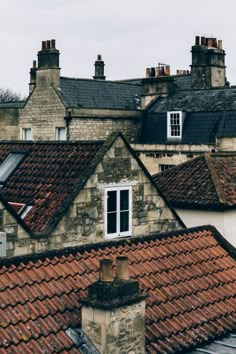 an old building with red tiled roofs and chimneys