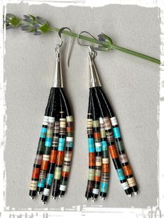 two pairs of earrings with multicolored beads hanging from the end of each ear