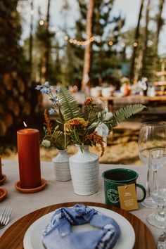 the table is set for dinner outside in the woods