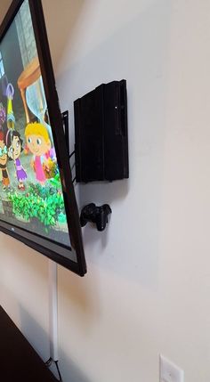 a flat screen tv mounted to the side of a wall next to a game controller